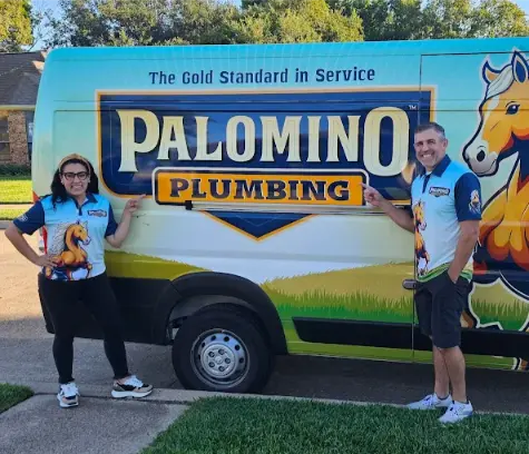 Two people in matching Palomino Plumbing shirts stand by a Palomino Plumbing van parked on a residential street.